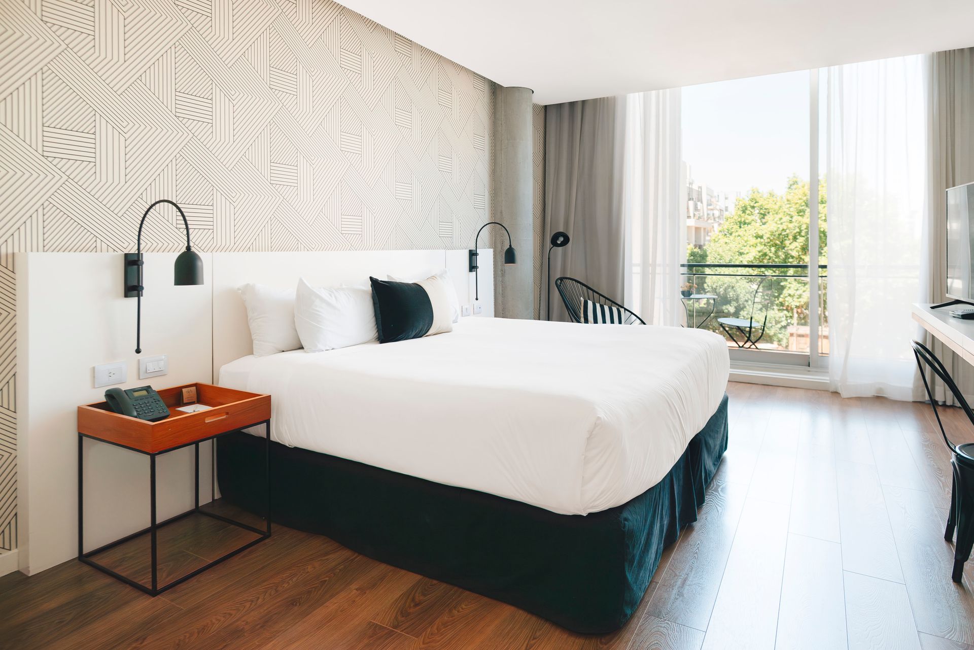 una habitación de hotel con cama king size, escritorio y televisión.