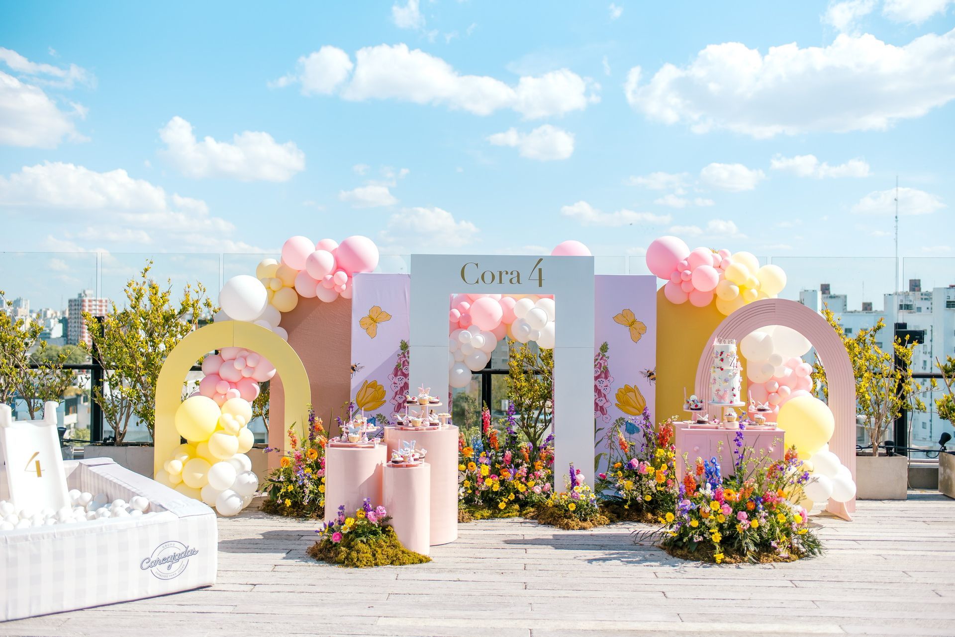 Un patio decorado con globos y flores para una fiesta de cumpleaños.