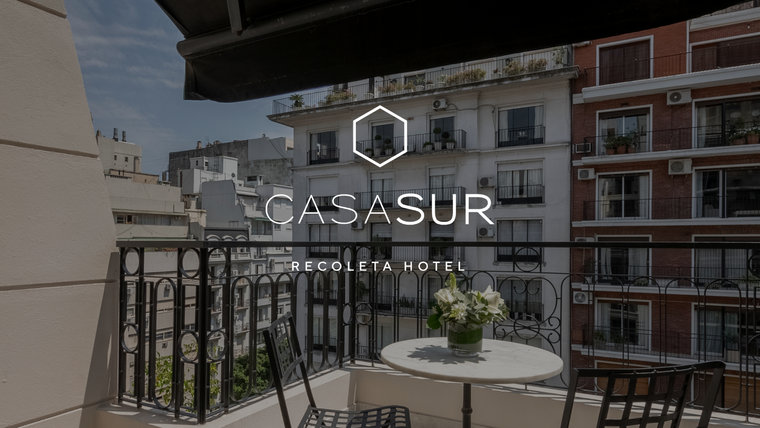 Una habitación de hotel con cama, escritorio y silla.