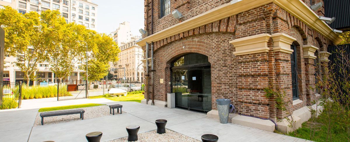 Un edificio de ladrillo con un patio enfrente.