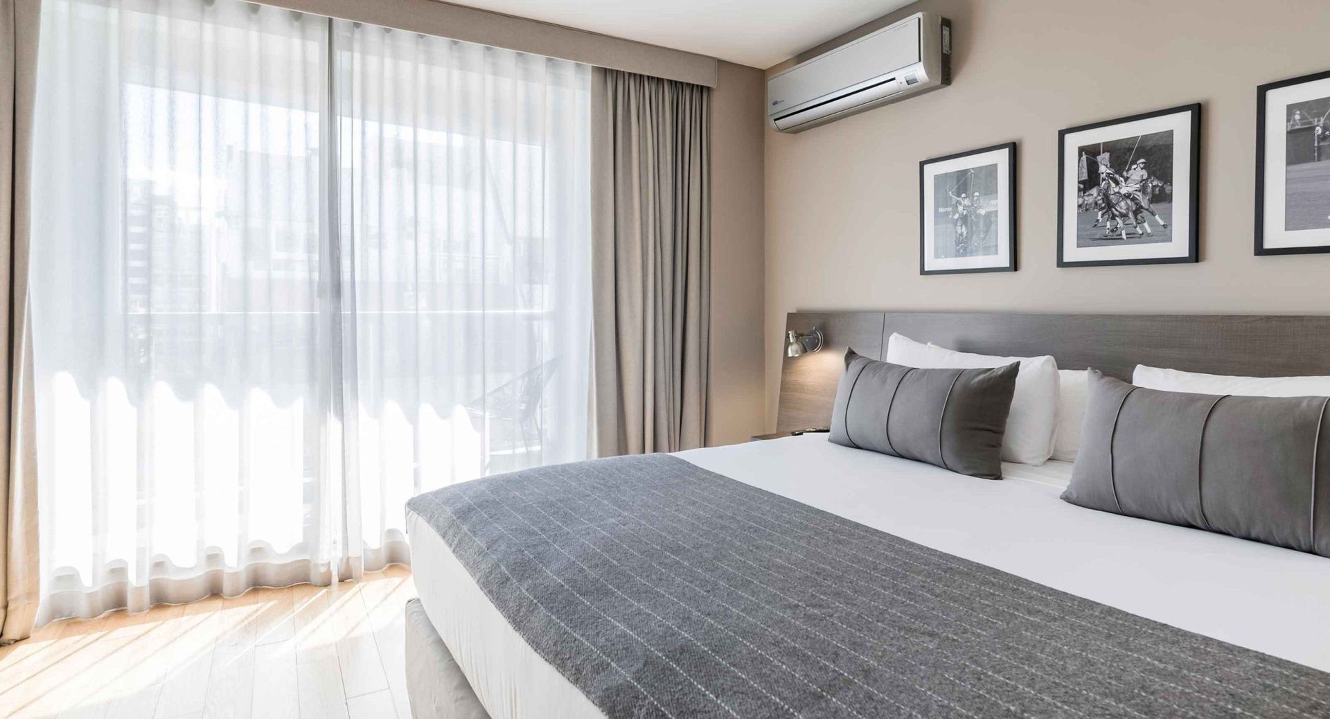 Una habitación de hotel con una cama grande, puertas corredizas de vidrio y una ventana.