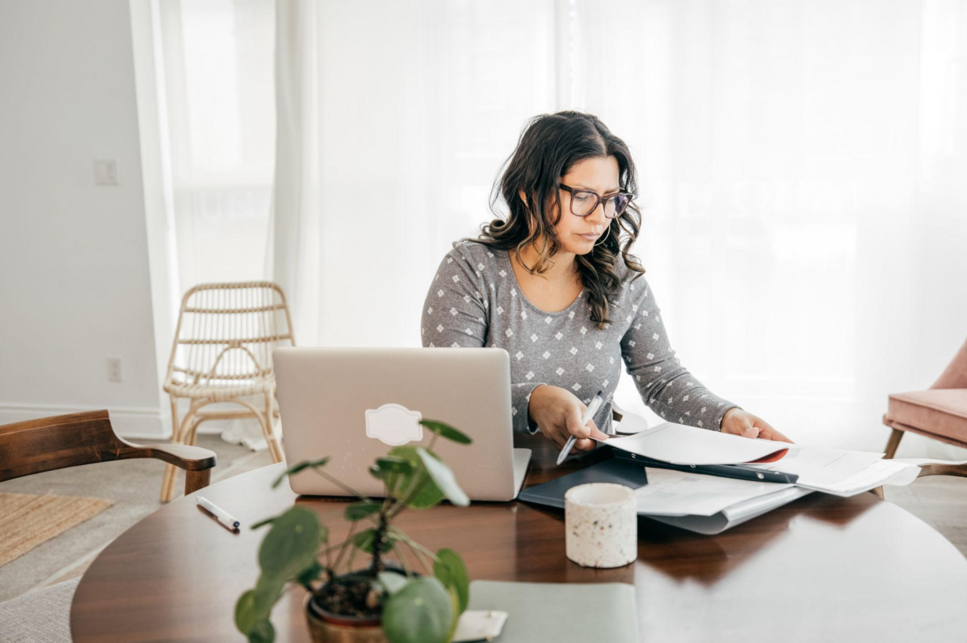 Self-employed professional reviewing business income documents and mortgage paperwork at a desk in B
