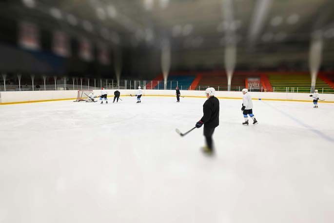 Ice hockey practice on a rink; players skating and stickhandling.