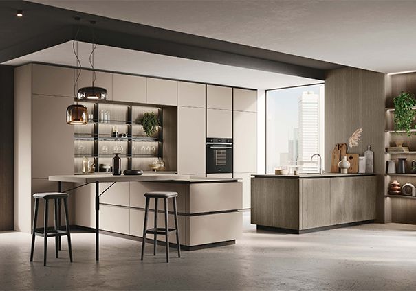 Cucina moderna con mobili beige, isola con sgabelli, forno incorporato e ampie finestre.
