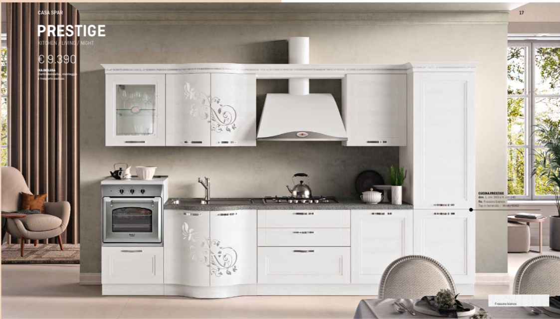 Cucina bianca con mobili decorati, elettrodomestici in acciaio inossidabile e zona pranzo.