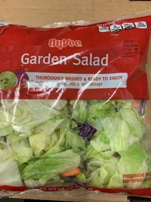 A bag of garden salad is sitting on a table.