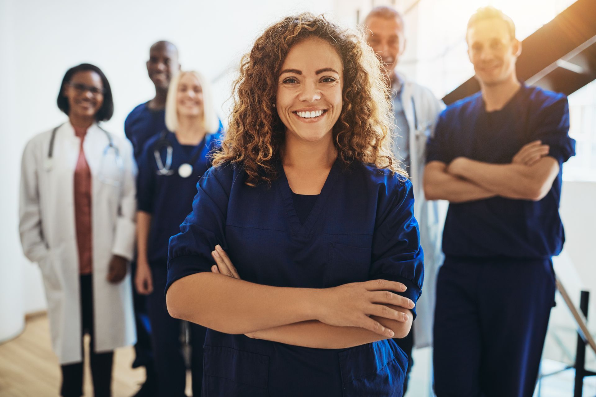 A group of doctors and nurses are standing next to each other in a hospital.