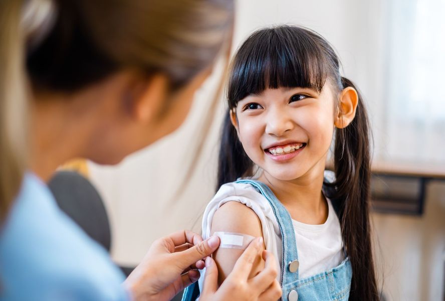 A little girl is getting an injection in her arm.
