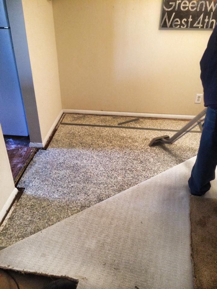 Bent carpet at a doorway with a person standing nearby in a hallway