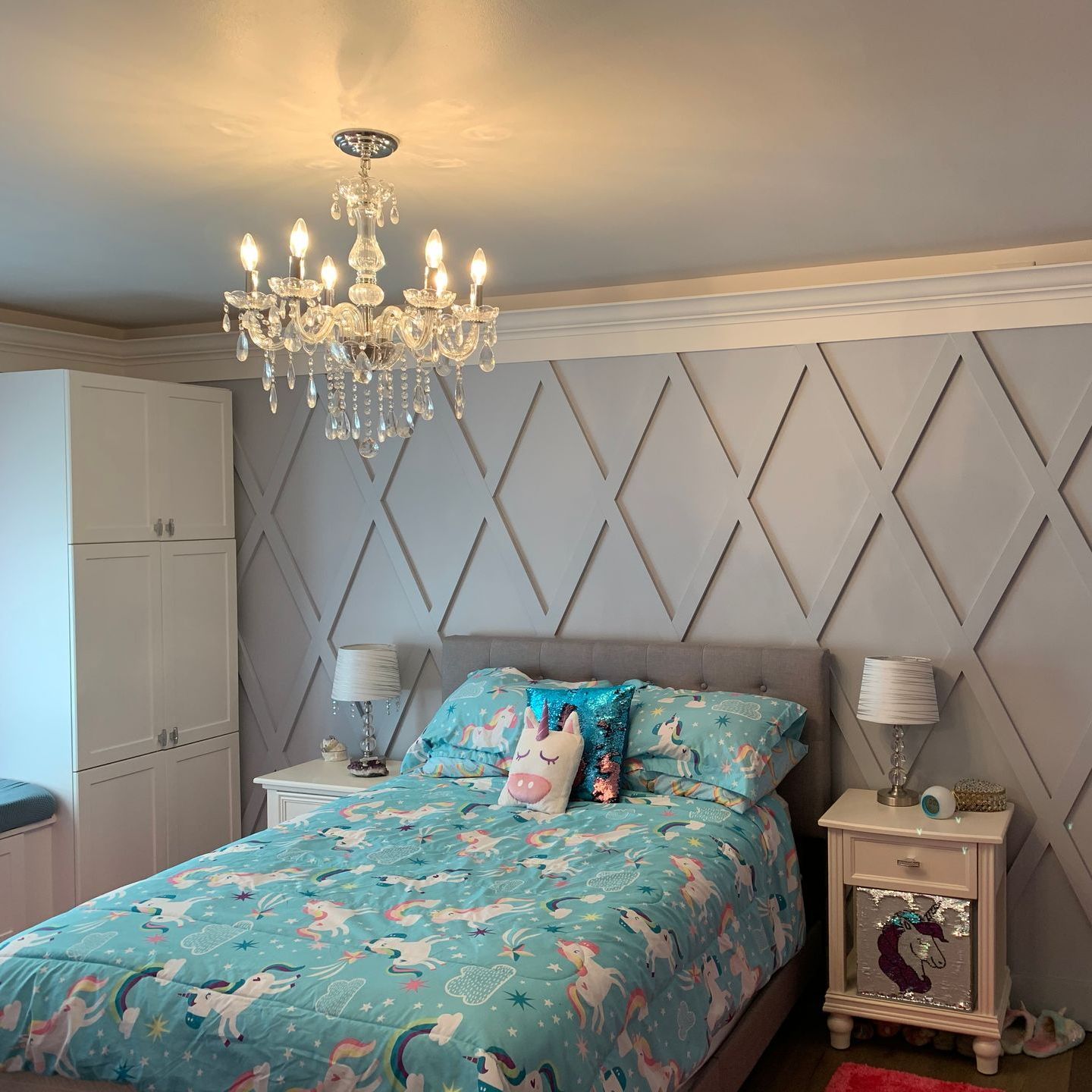 A bedroom with a bed and a chandelier hanging from the ceiling