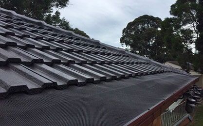 A Roof with a lot of Tiles on it and trees in the Background — Roof Repairs in Maitland, NSW