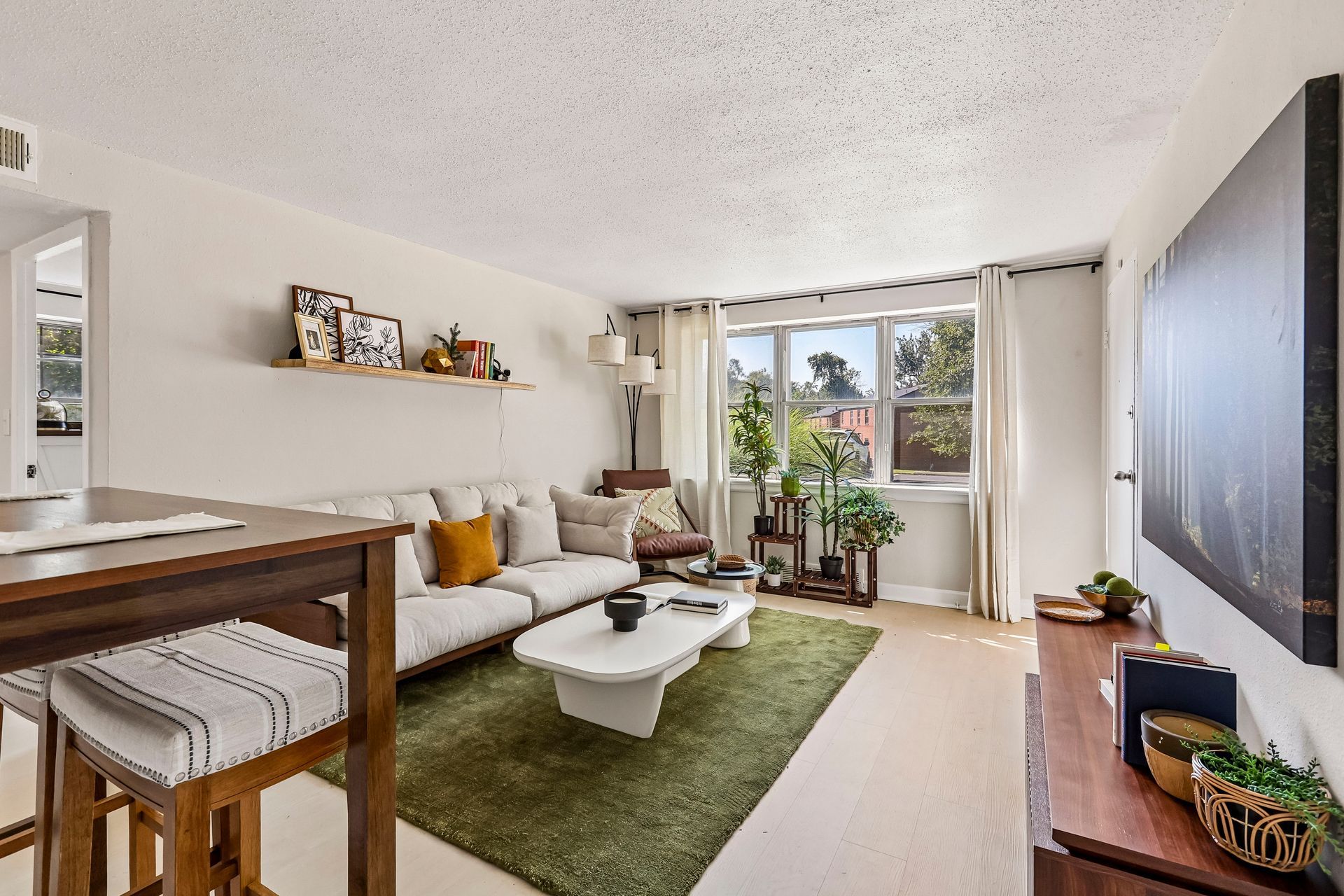 Apartment living room with a sofa, coffee table, and large window at Brickline Apartments