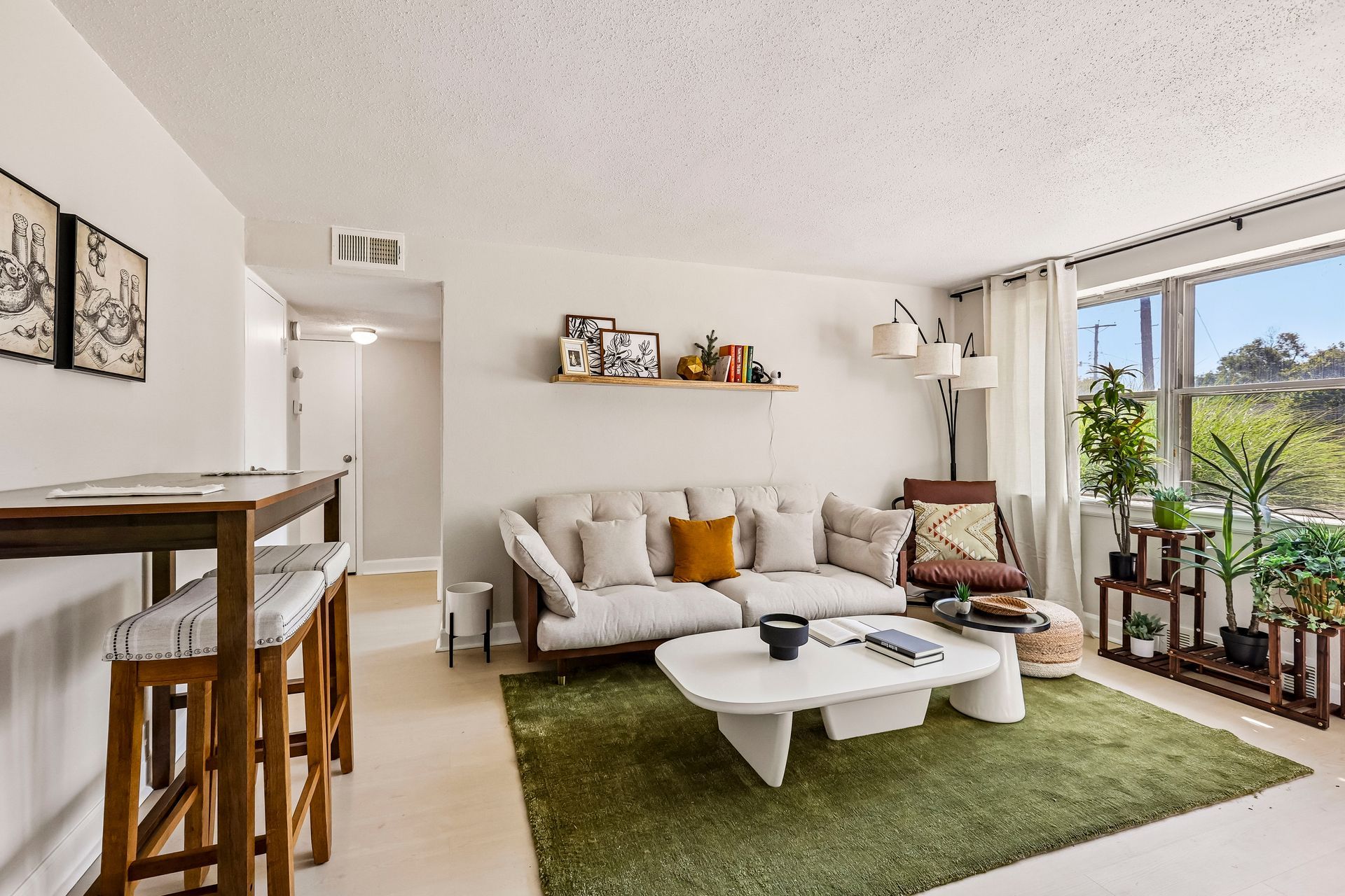 Furnished living room with a sofa and adjacent dining area at Brickline Apartments