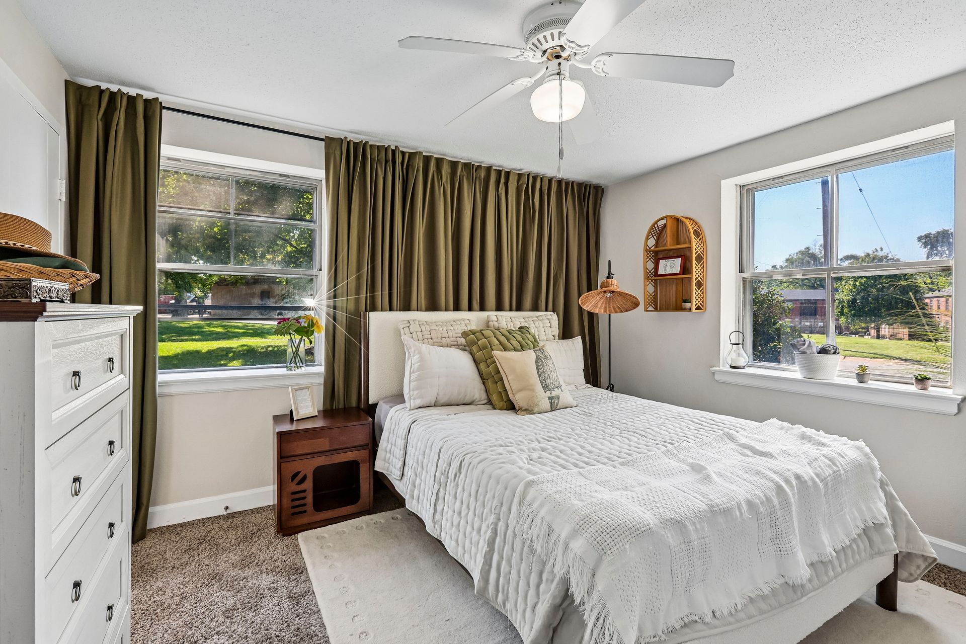 Apartment bedroom with two windows, a dresser, and ceiling fan at Brickline Apartments