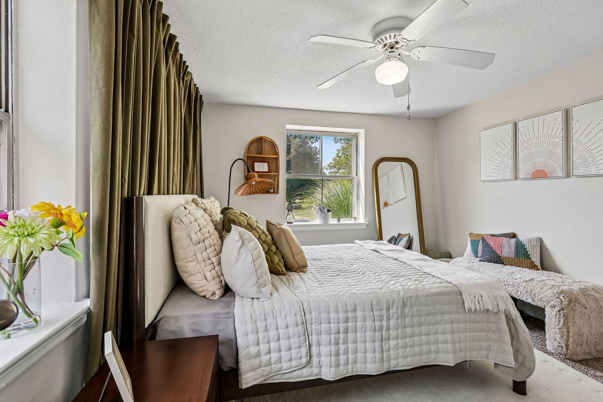 Furnished bedroom with a bed, window, and white ceiling fan at Brickline Apartments