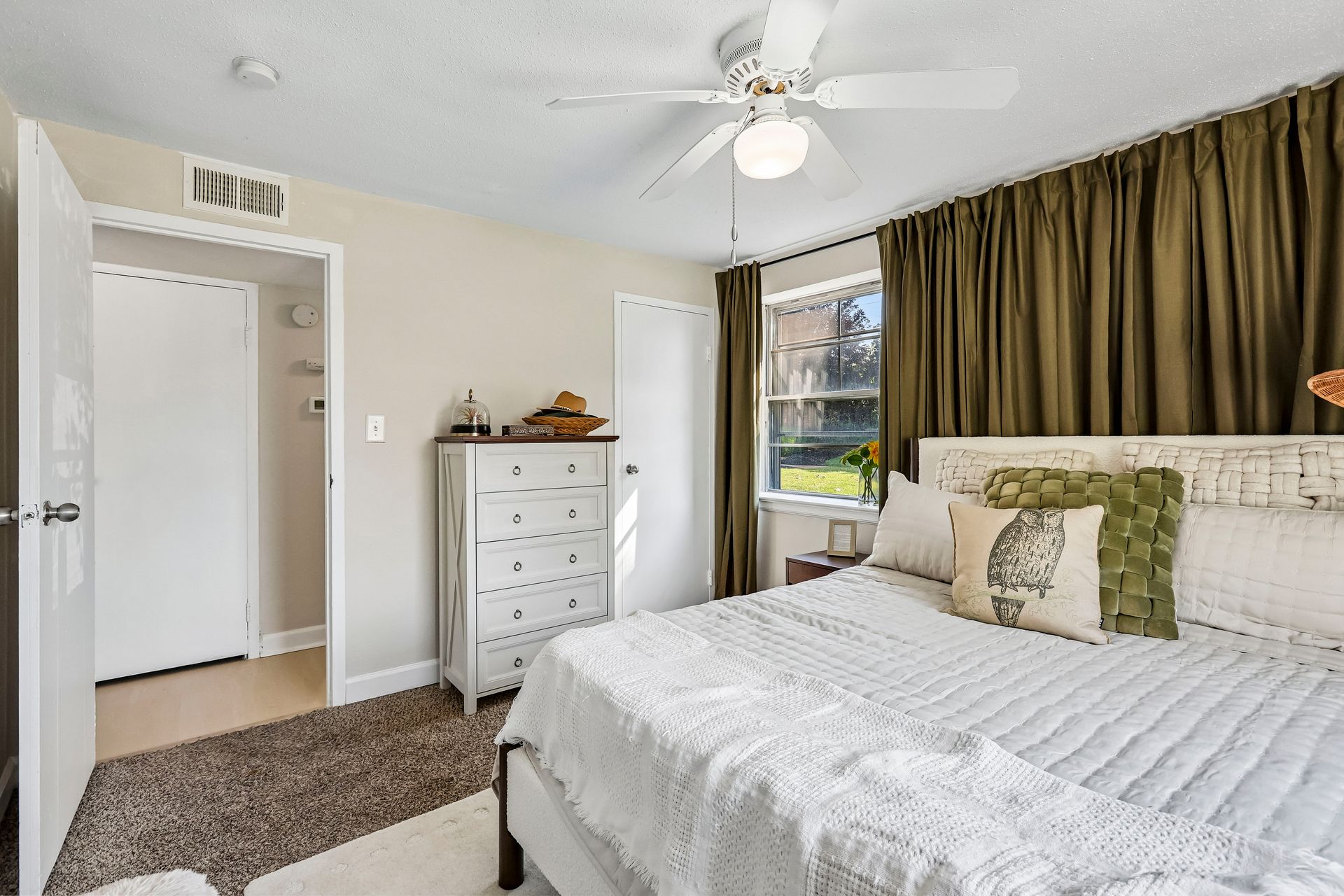 Furnished bedroom with a dresser and closet doors at Brickline Apartments