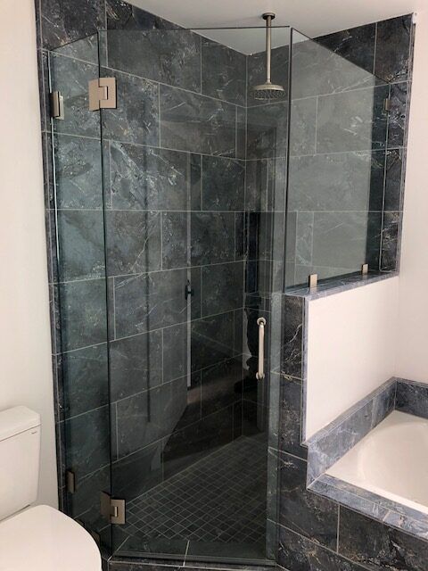 A bathroom with a walk in shower and a bathtub.
