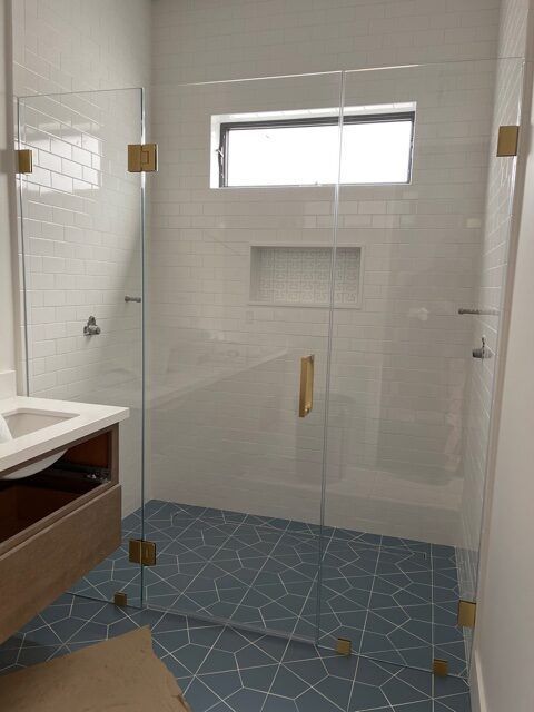 A bathroom with a glass shower door and a sink.