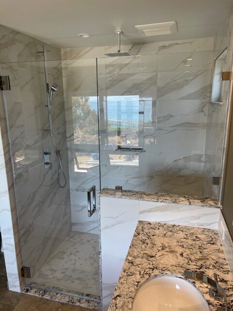 A bathroom with a walk in shower and a sink.