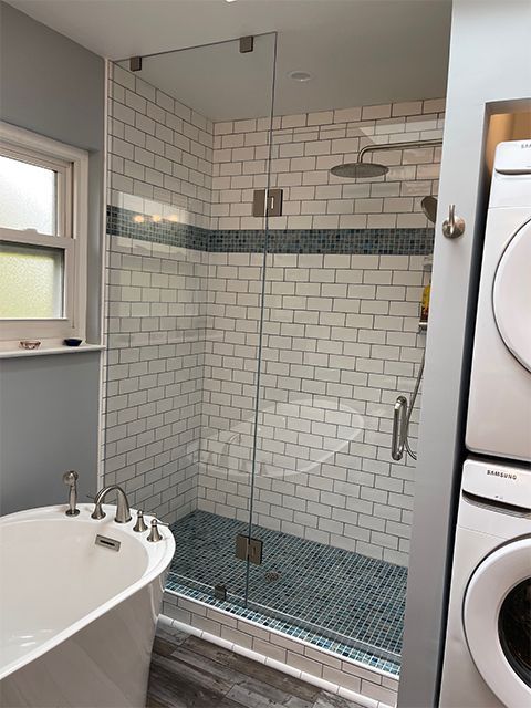 A bathroom with a bathtub and a shower with a glass door.