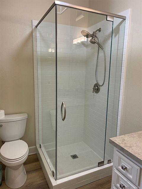A bathroom with a toilet and a shower stall with a glass door.