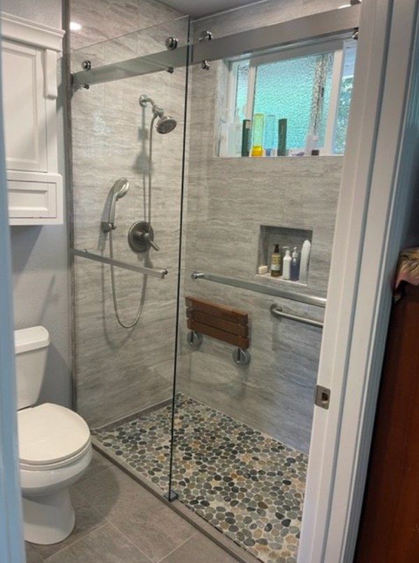 A bathroom with a walk in shower and a toilet.