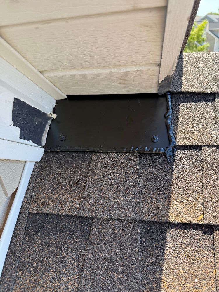 Damaged roof flashing under eaves with exposed black sealant and missing siding trim