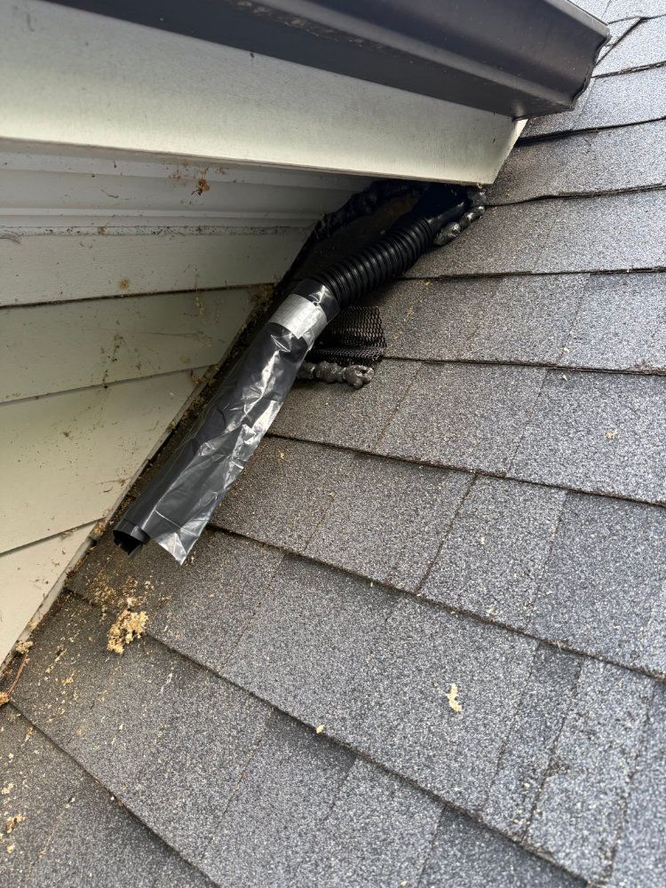Damaged roof vent pipe wrapped in duct tape at the edge of a shingled roof
