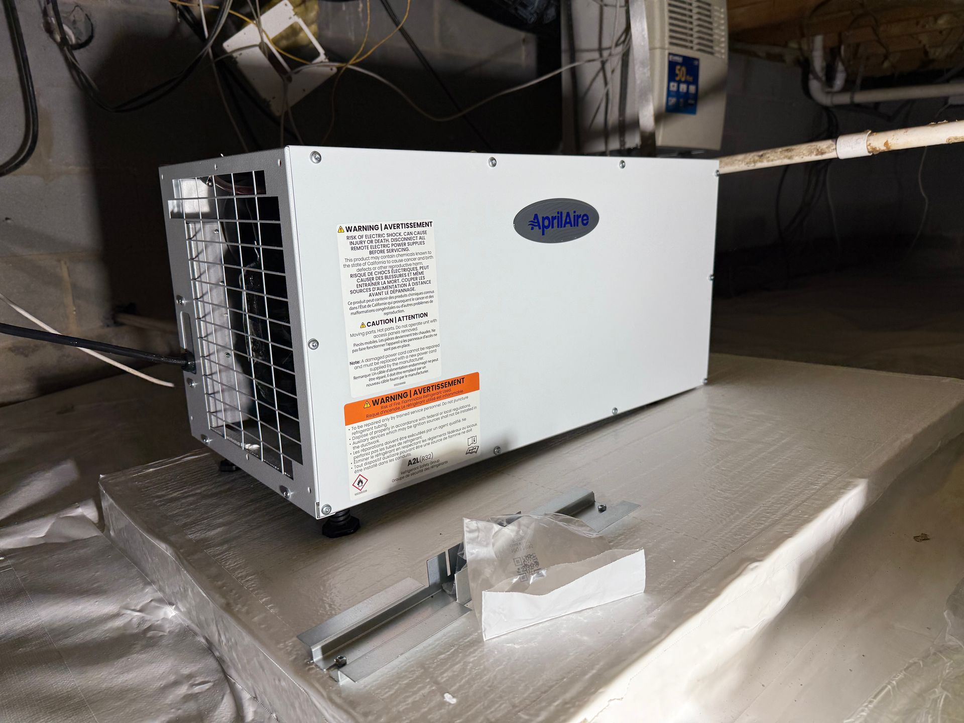 White HVAC unit on a rooftop with detached metal bracket pieces in front of it