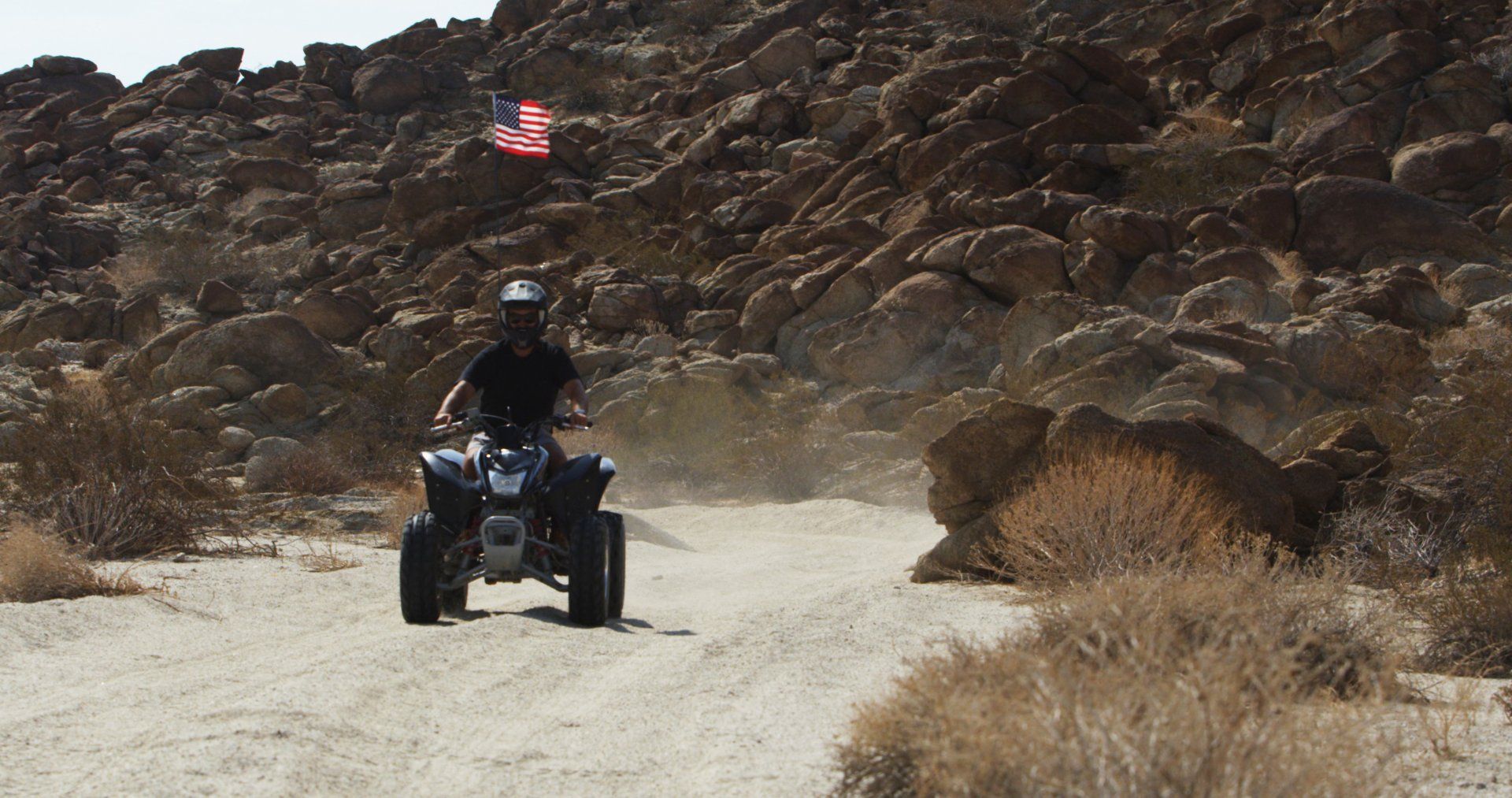 man on ATV driving through mountain