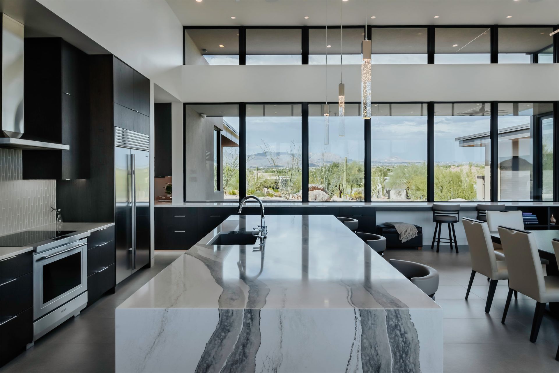 A kitchen with a large island and a lot of windows on a Collective construction house