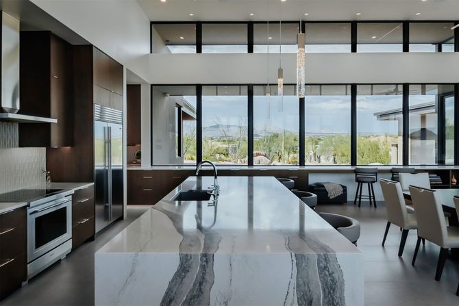 A kitchen with a large island and a lot of windows