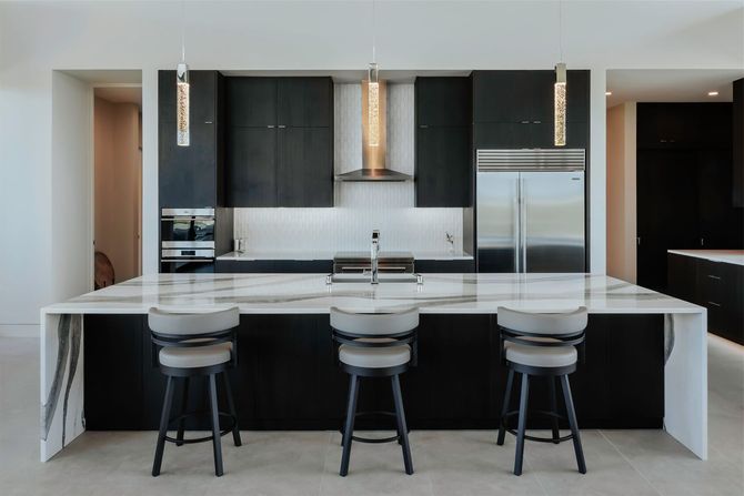 A kitchen with black cabinets and white counter tops