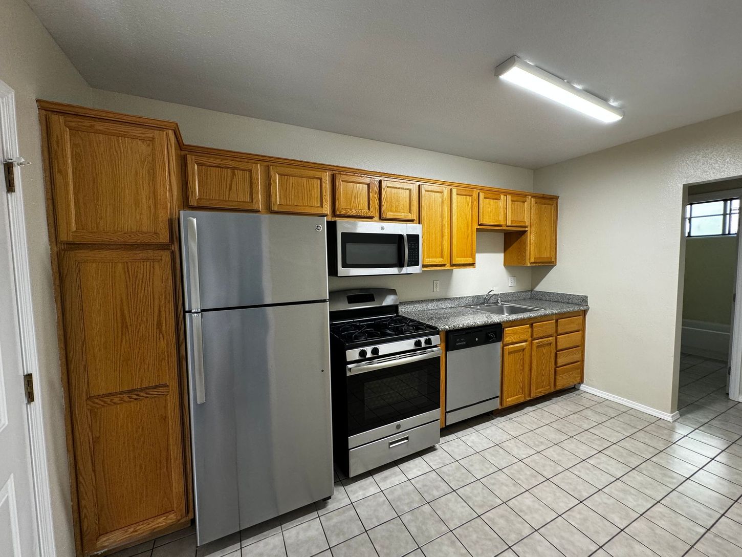 A kitchen with stainless steel appliances and wooden cabinets