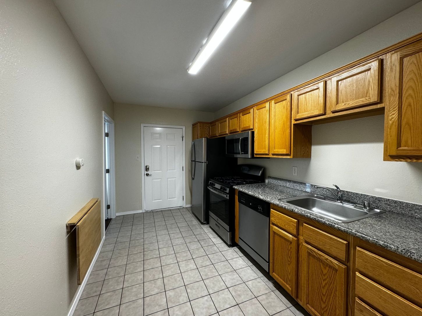 A kitchen with wooden cabinets and granite counter tops