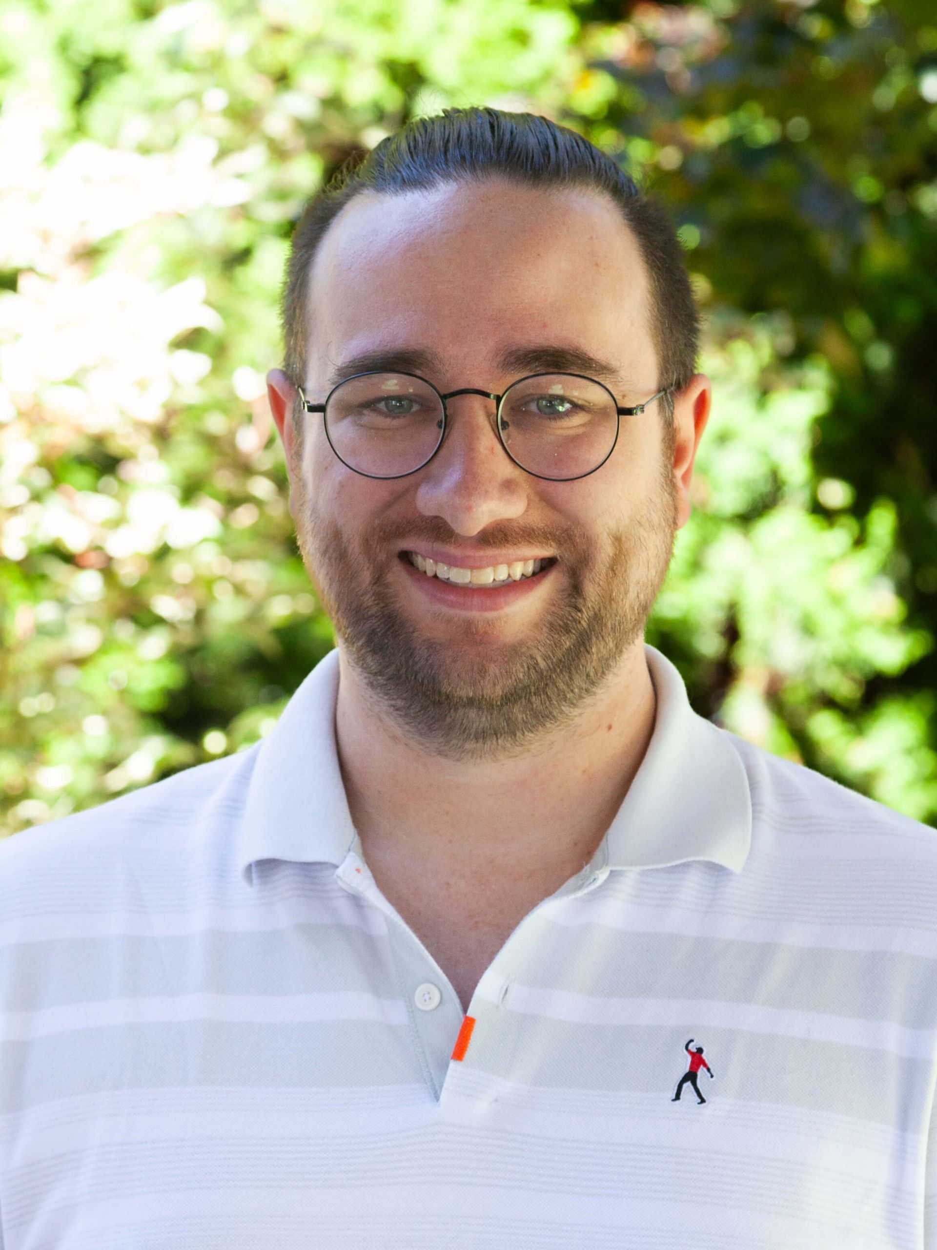 Man wearing glasses and a colored white shirt.