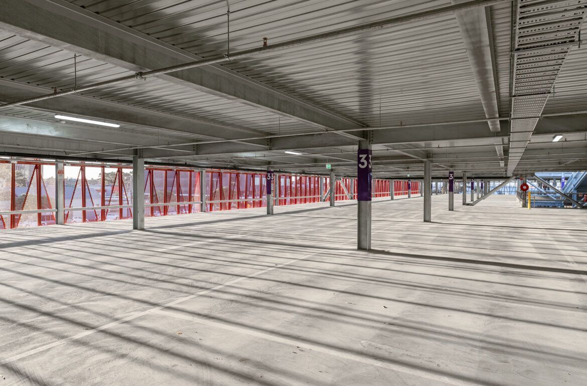 A large empty parking garage with a lot of cars parked in it.