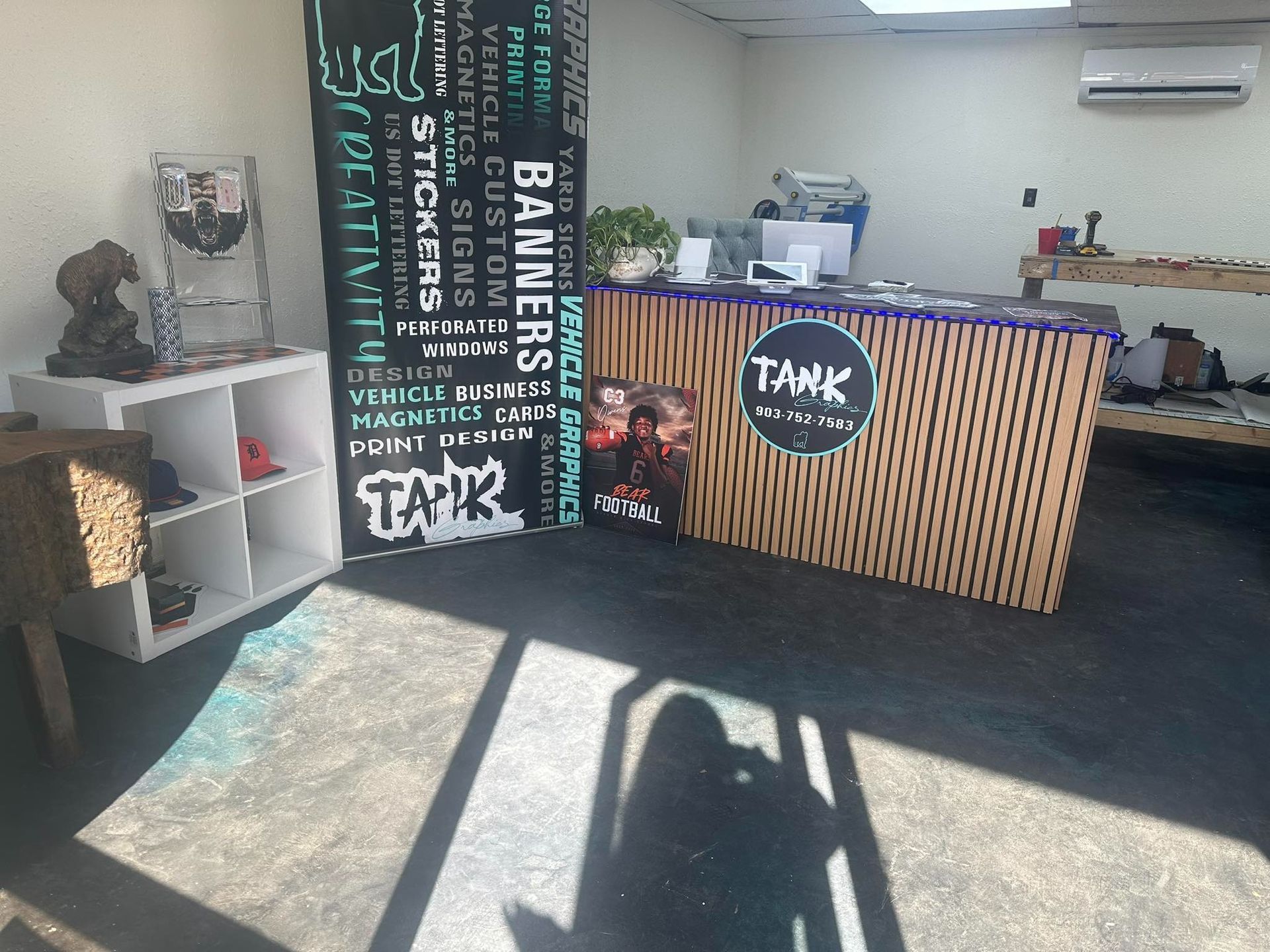 Coffee shop counter with wood slats, black menu board, and bright sunlight on the floor.