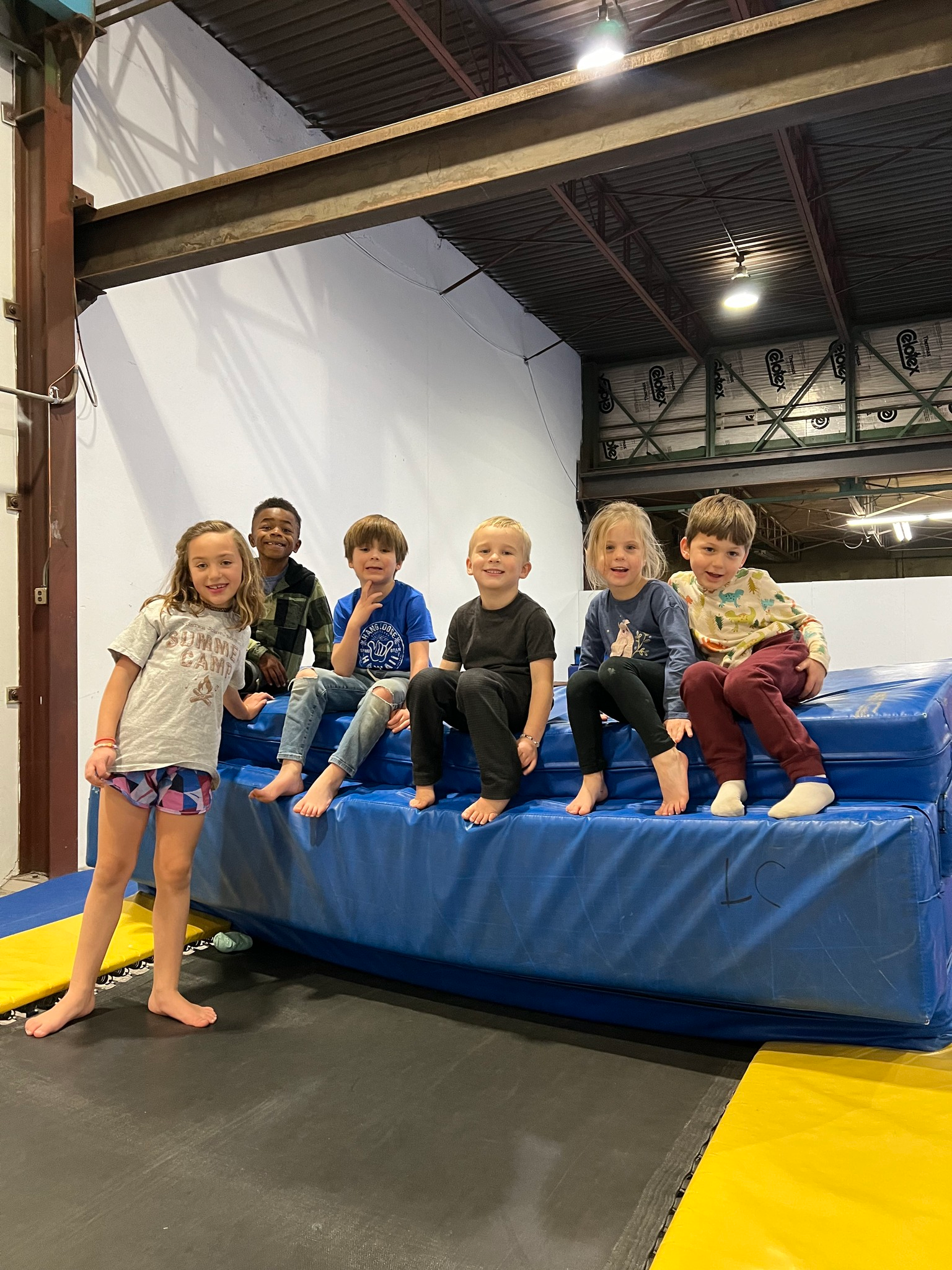 Kids sitting together on the mat at a gym party