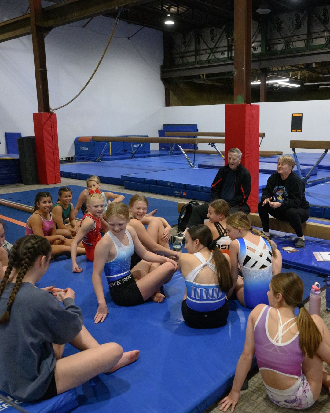 Gymnasts sitting together with their coaches
