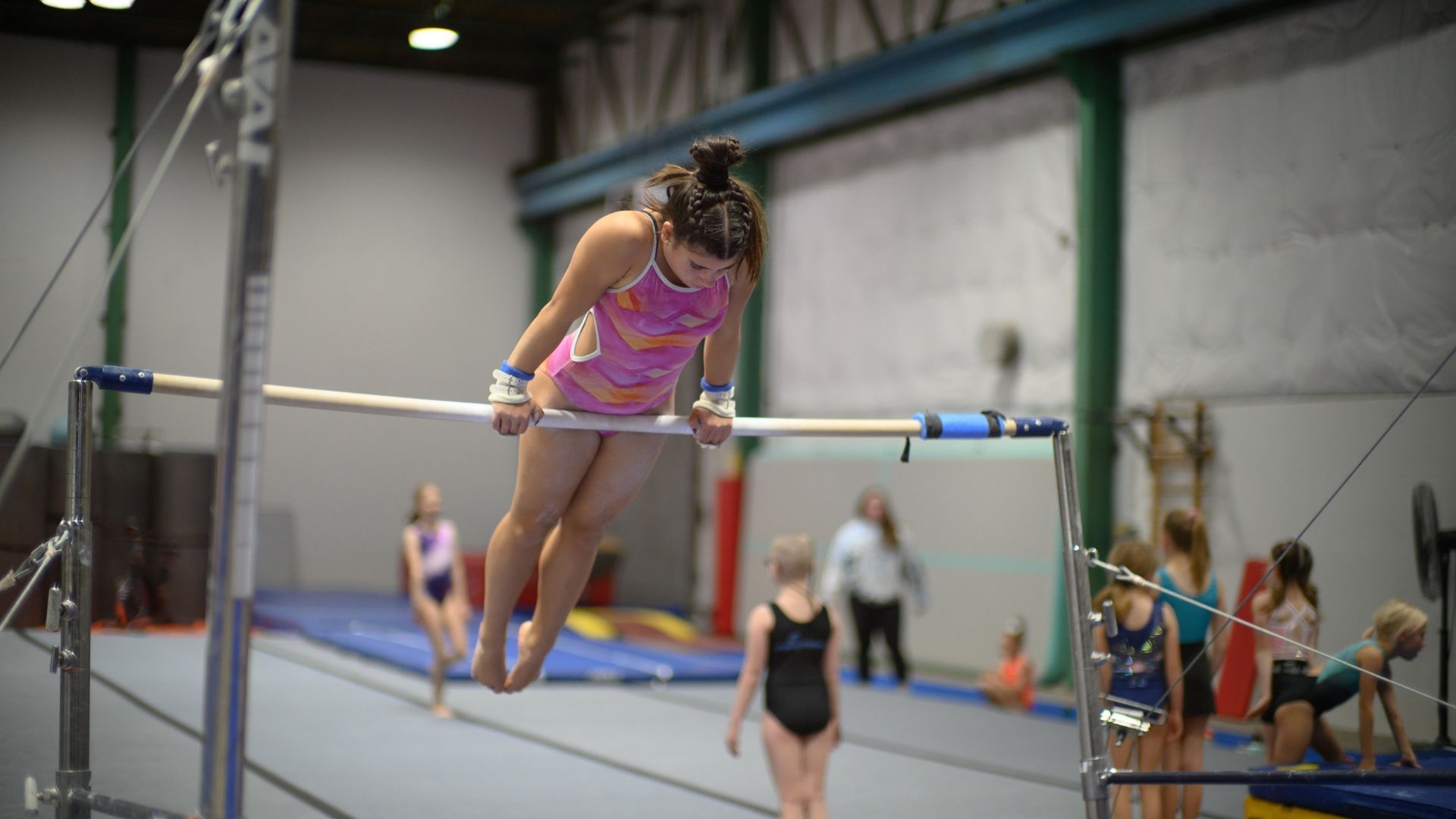 Xcel team gymnast practicing on the bars