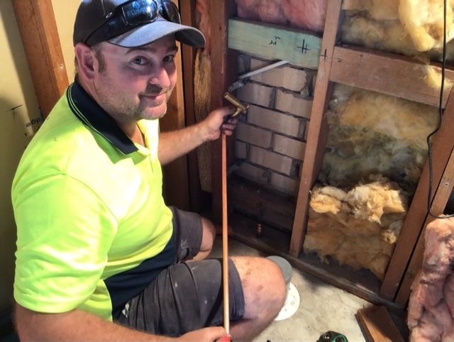 A plumbing camera set up to find blockage issues going down a pipe and some tools around on a tiled floor — Delaney Plumbing Services In Taree, NSW