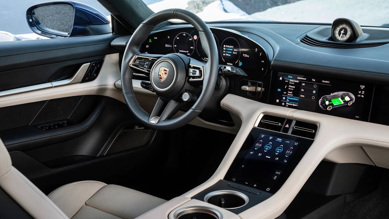 The interior of a porsche taycan is shown with a steering wheel and dashboard.
