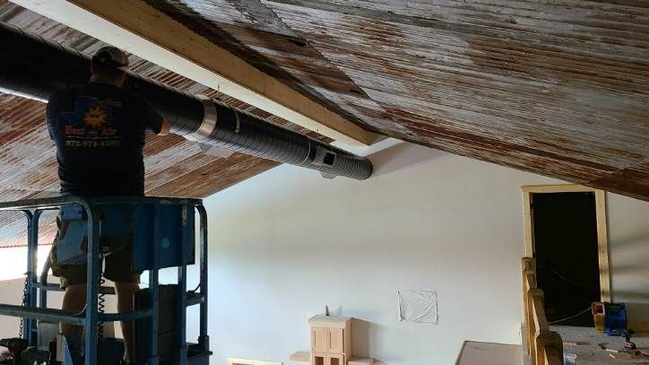 An air conditioner is being installed in the attic of a house.