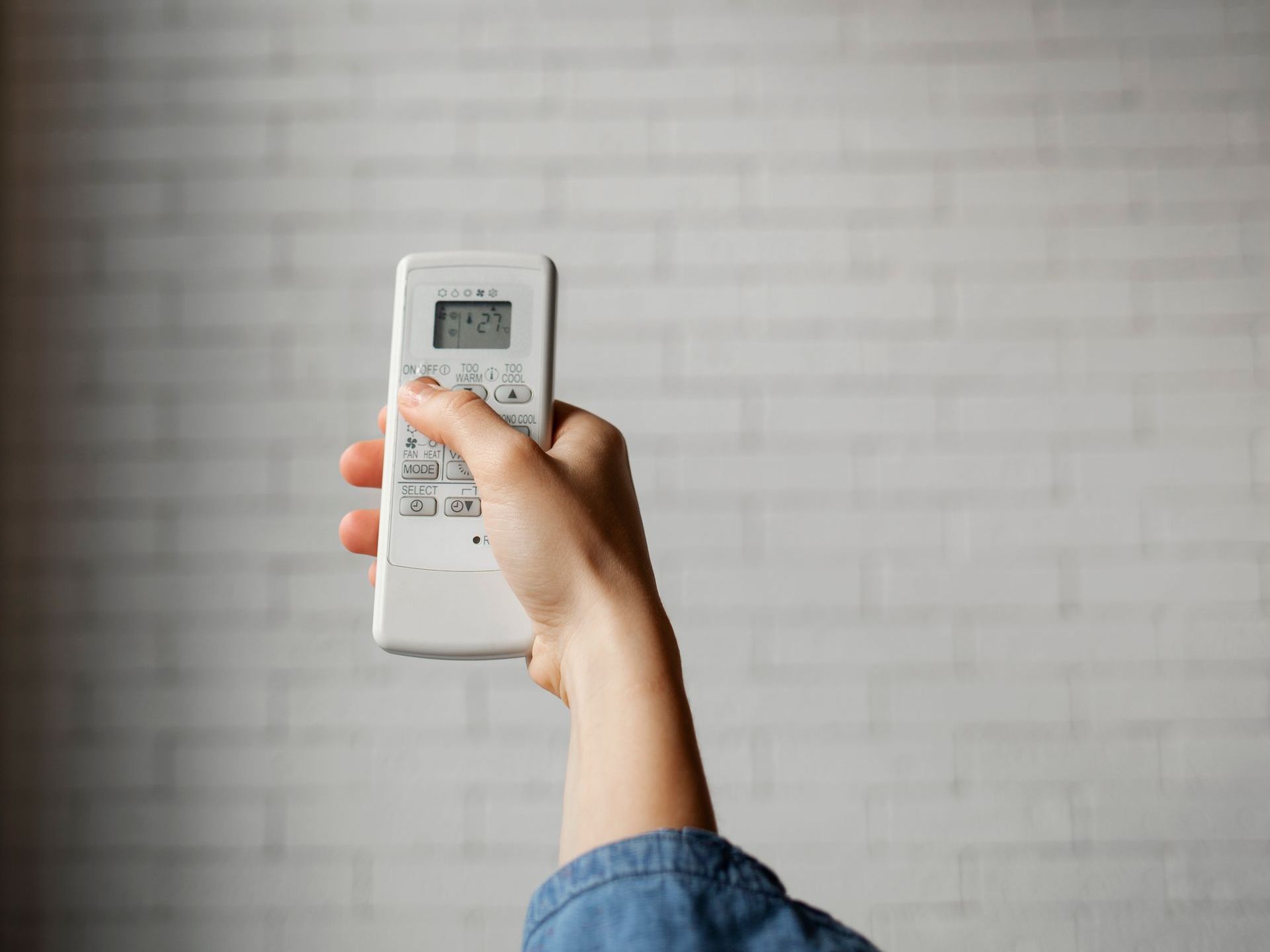 A person is holding a remote control in their hand.