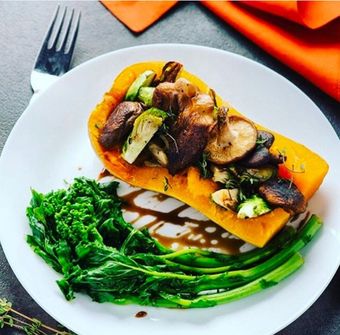 Butternut squash stuffed with roasted vegetables, served with broccoli rabe and a balsamic glaze.