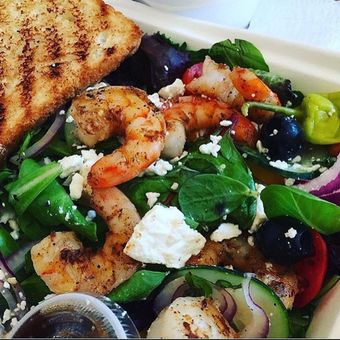Grilled shrimp salad with feta, olives, and toasted bread.