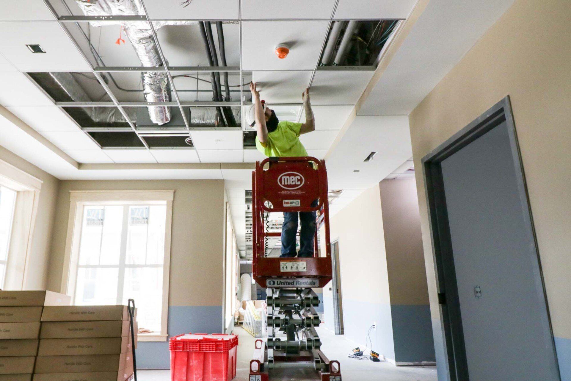 Electrician working on ceiling titles