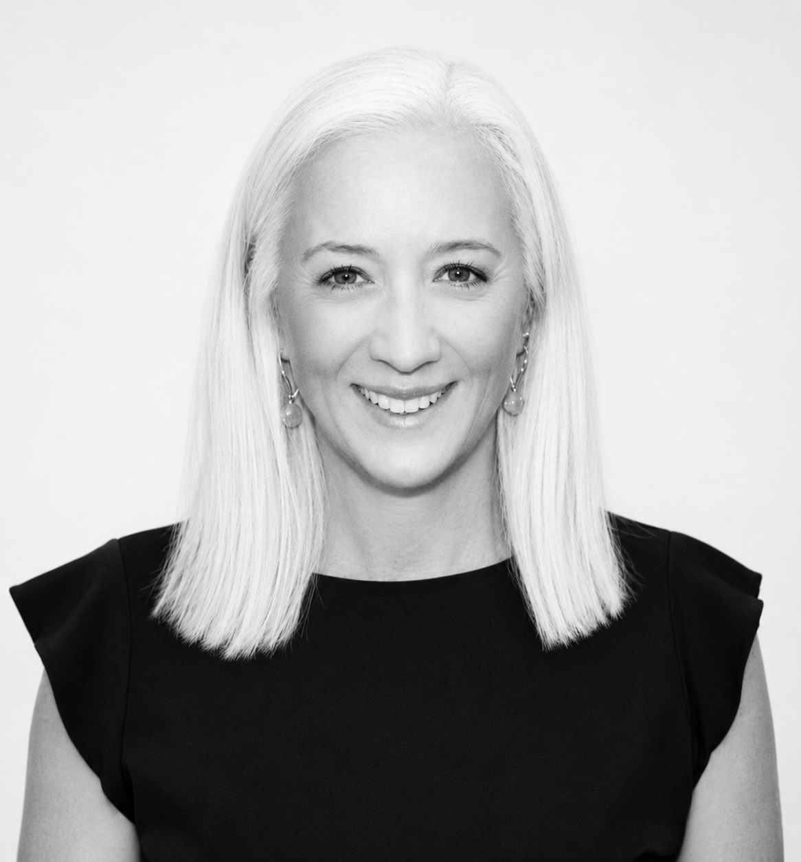 Smiling woman with straight light hair in a black top against a white background