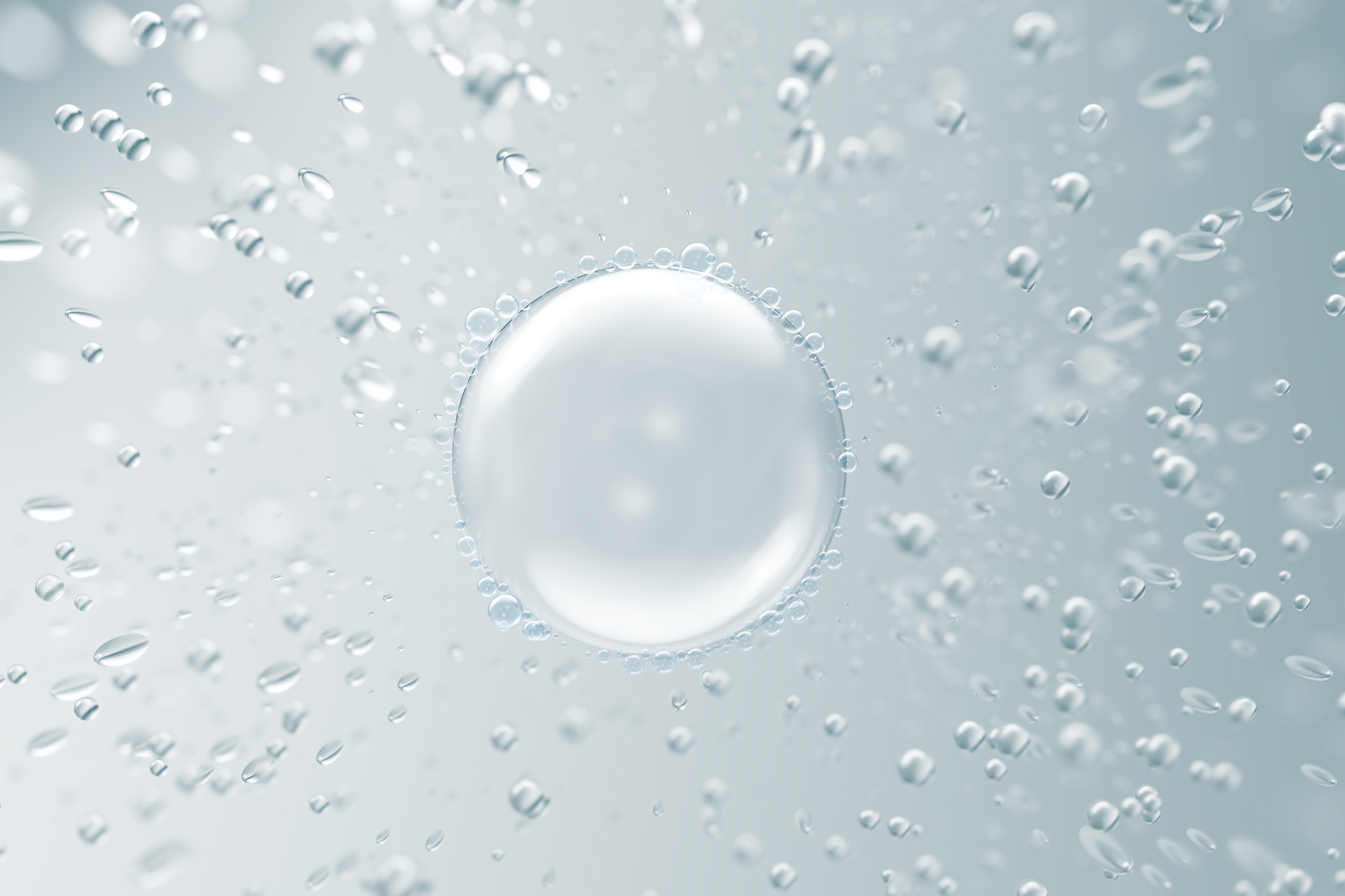 Large bubble surrounded by smaller bubbles in a clear, light blue liquid.